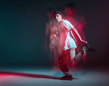 Şık genç adam neon ışıkta hip-hop dansı yapıyor. Dans okulu posteri. Uzun pozlu çekim