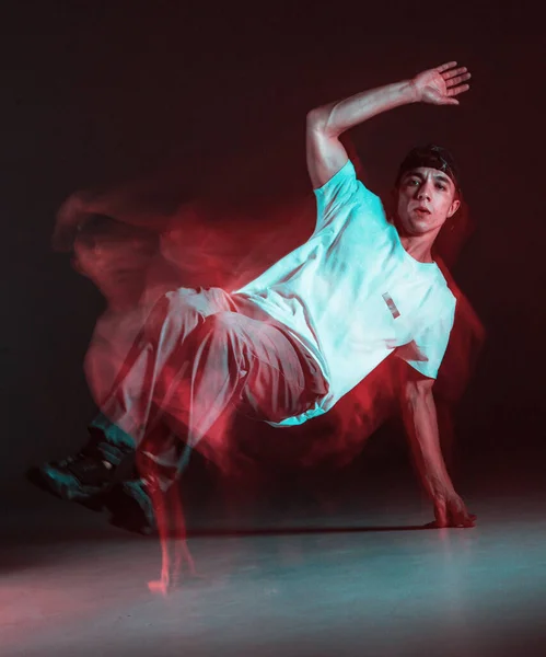 Stylowy młody facet breakdancer tańczący hip-hop w neonowym świetle. Długa ekspozycja — Zdjęcie stockowe