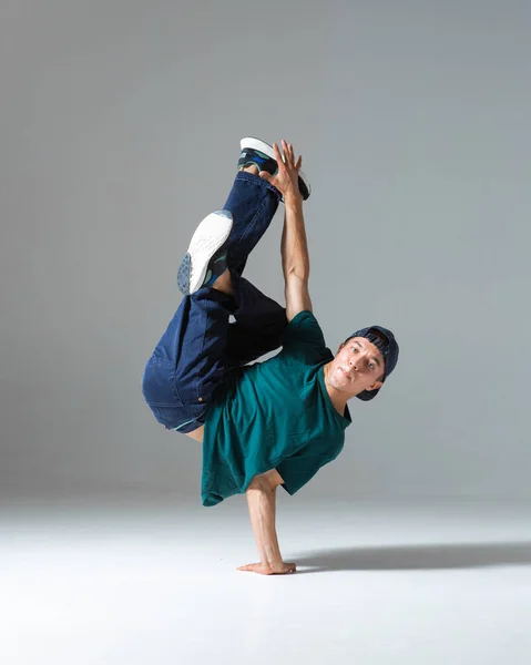 Havalı break dansçı çocuk gri arka planda tek başına stüdyoda dans ediyor. Breakdance posteri — Stok fotoğraf