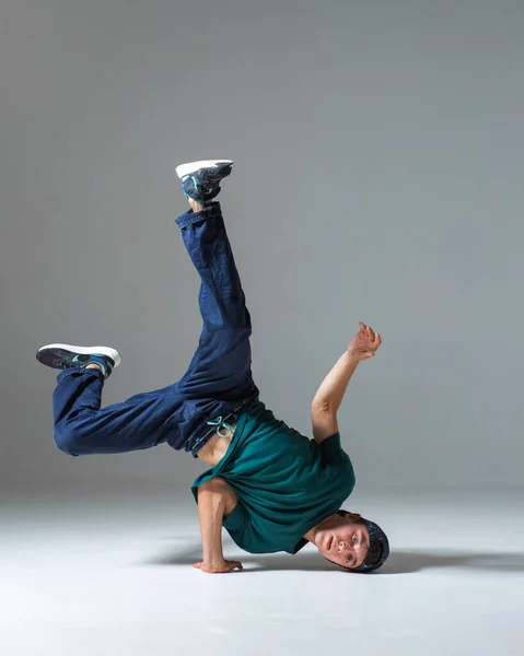 Fajny facet breakdancer tańczy z jednej strony na szarym tle. Plakat śniadaniowy — Zdjęcie stockowe