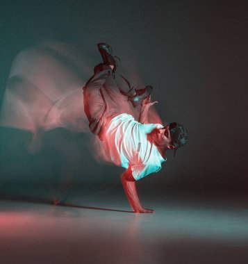 Şık genç adam neon ışıkta hip-hop dansı yapıyor. Dans okulu posteri. Uzun pozlu çekim