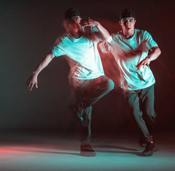 Stylowy młody facet breakdancer raper taniec hip-hop w świetle neonu. Długa ekspozycja — Zdjęcie stockowe