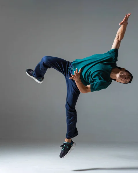 Fajny młody facet breakdancer skacze taniec hip-hop odizolowany na szarym tle. Plakat szkoły tańca. Lekcje tańca break dance — Zdjęcie stockowe