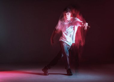 Şık genç adam neon ışıkta hip-hop dansı yapıyor. Dans okulu posteri. Uzun pozlu çekim