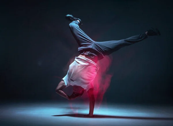 Fajny młody facet breakdancer tańczący hip-hop w neonowym świetle. Plakat szkoły tańca. Długa ekspozycja — Zdjęcie stockowe