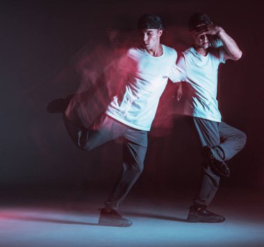 Şık genç adam neon ışıkta hip-hop dansı yapıyor. Dans okulu posteri. Uzun pozlu çekim