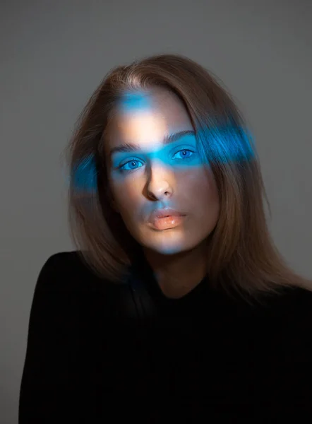 Trendiges Porträt der schönen Mädchen mit Neonlicht im Gesicht isoliert auf grauem Hintergrund im Studio — Stockfoto