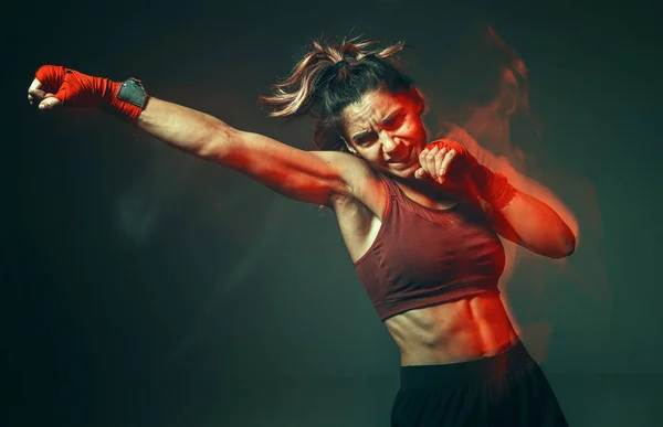 Cool girl fighter with relief abs makes jab in studio in neon light. Concepto de deporte y motivación. Disparo de larga exposición — Foto de Stock