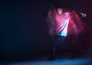 Şık genç adam neon ışıkta hip-hop dansı yapıyor. Dans okulu posteri. Uzun pozlu çekim