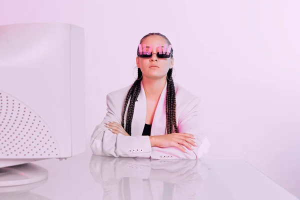 Portret van Aziatische vrouwelijke kantoormedewerker in zonnebril met stickers aan bureau met verouderde computer in neon licht — Stockfoto