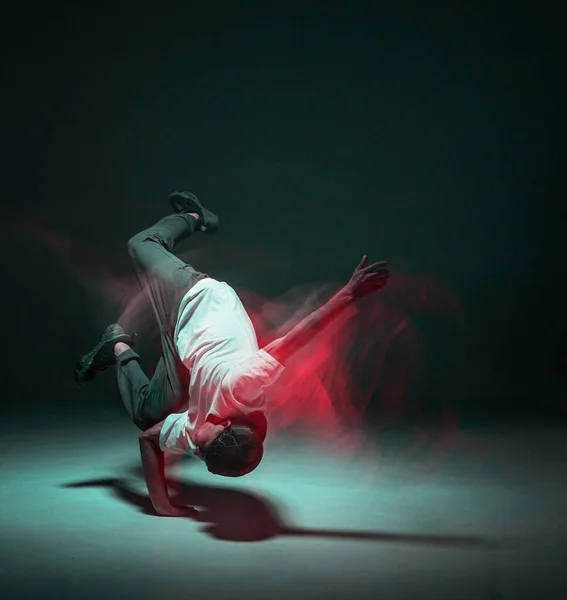 Şık genç adam neon ışıkta hip-hop dansı yapıyor. Dans okulu posteri. Uzun pozlu çekim