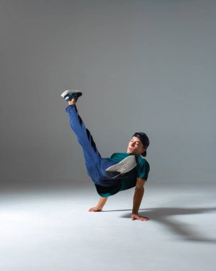 Gri arka planda fotokopi alanı olan havalı bir adam stüdyoda dans ediyor. Dans okulu posteri