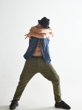 Beyaz arka planda izole edilmiş bir şekilde şapka dansı yapan şık bir dansçı. Breakdance dersleri