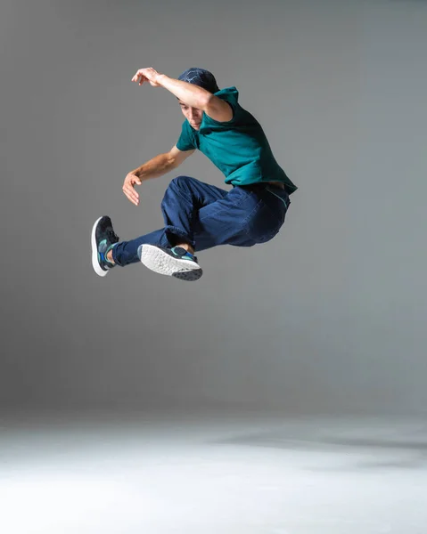 Fajny człowiek breakdancer skacze taniec hip-hop odizolowany na szarym tle. Plakat szkoły tańca. Lekcje tańca break dance — Zdjęcie stockowe