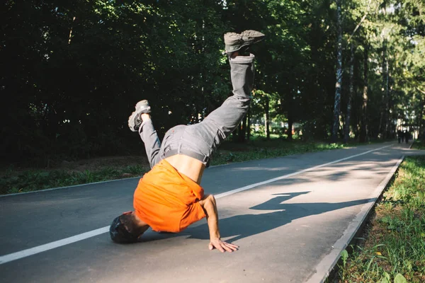 Um rapaz fixe a dançar breakdance na estrada, no parque, no Verão. Cartaz da escola Breakdancing — Fotografia de Stock