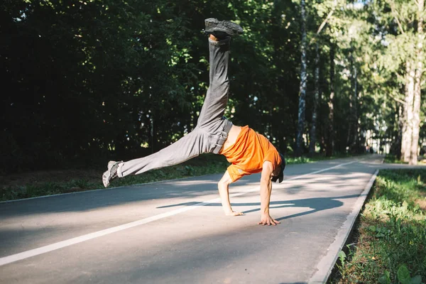 Legal jovem cara breakdancer danças no o estrada no o parque no verão — Fotografia de Stock