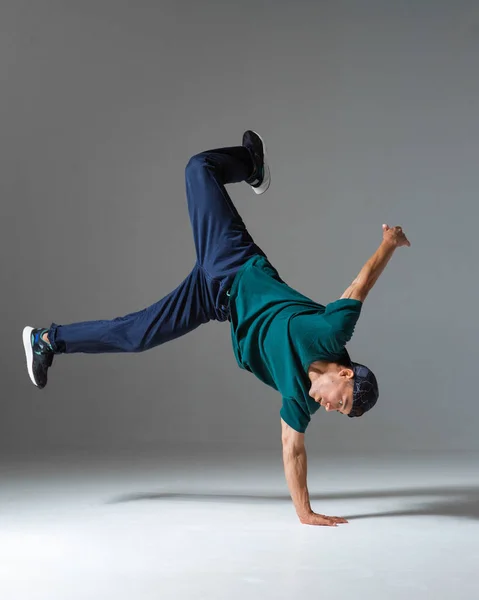 Fajny facet breakdancer taniec na podłodze odizolowany na szarym tle. Lekcje przerwy — Zdjęcie stockowe