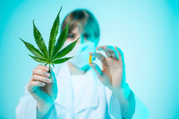 Médecin femme avec pilule de chanvre et feuille de cannabis dans les mains en studio. Compléments alimentaires biologiques — Photo