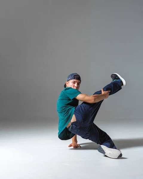 Fajny facet breakdancer taniec niższe break dance odizolowany na szarym tle. Lekcje tańca break dance — Zdjęcie stockowe