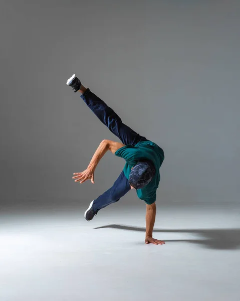 Király b-boy táncol az egyik oldalon a stúdióban elszigetelt szürke háttérrel. Breakdance poszter — Stock Fotó