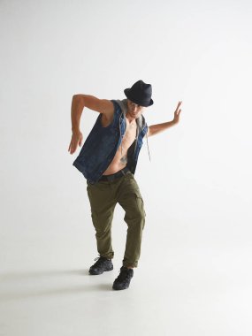 Beyaz arka planda izole edilmiş bir şekilde şapka dansı yapan şık bir dansçı. Breakdance Okulu