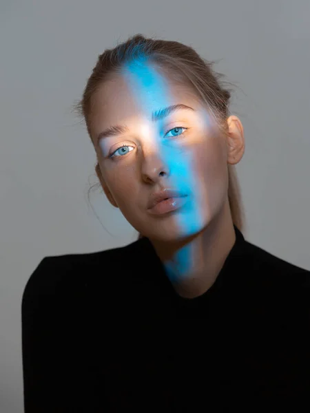 Stylová krásná mladá dívka s modrým světlem na tváři. Krásný portrét — Stock fotografie