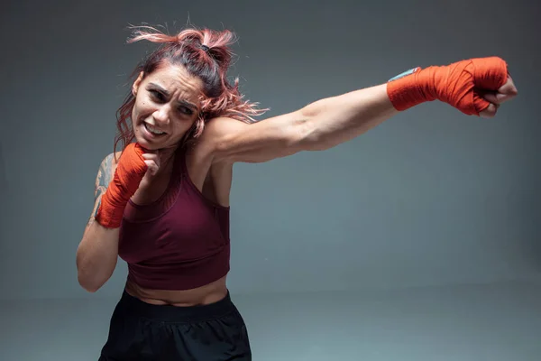 Cool lutador feminino treina em bandagens de boxe em estúdio isolado em fundo cinza. Conceito de desporto feminino — Fotografia de Stock