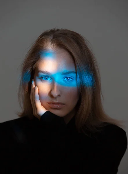 Kreatív stúdió portré fiatal nőkről neonkék fénnyel az arcán — Stock Fotó