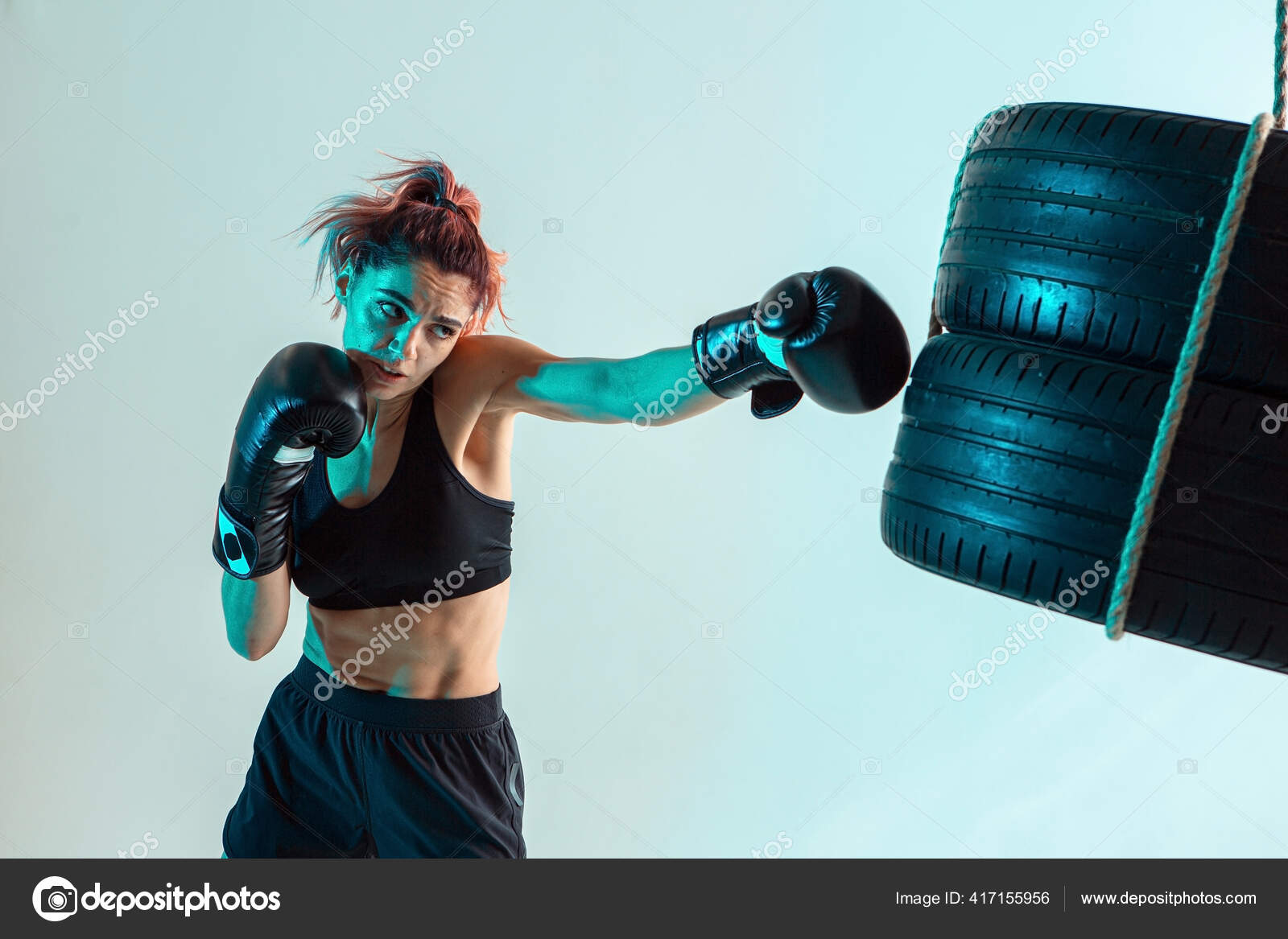 Una luchadora con guantes de boxeo golpea los neum ticos con su