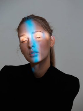 Yüzünde neon ışığı olan uykulu genç bir kadının portresi.