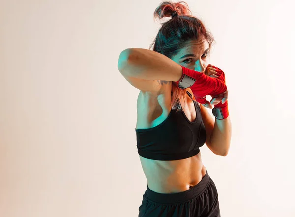 Ellerinde bandajlar olan bir kadın boksör bir üst el ve dirsek vuruşu yapar.. — Stok fotoğraf