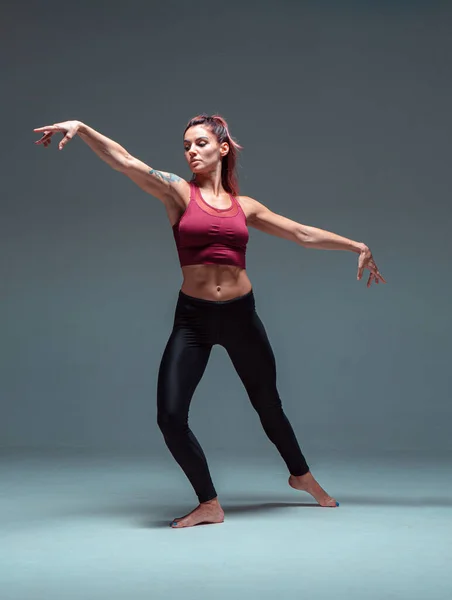 Ganzkörperporträt einer modernen Tänzerin, die in Sportbekleidung tanzt. — Stockfoto