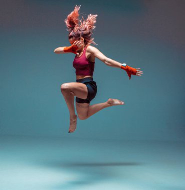 Genç bir kadın dövüşçü atlama vuruşu yapıyor..