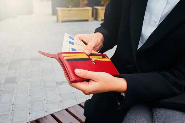 Girl with an open wallet. Money and credit cards in woman hands.