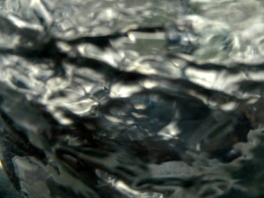 Arka plan veya doku için bulanık gümüş dönen türbülans sıvısı.