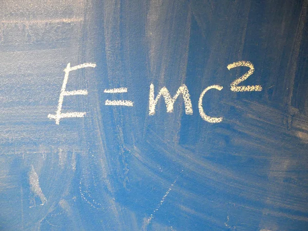 Mathematical formula e=mc2 squared written on a blue, relatively dirty chalkboard by chalk. — Stock Photo, Image