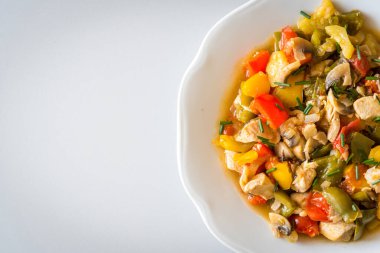 Beyaz tabakta ızgara sebzeli tavuk körili nugget. Sol tarafta boşluk