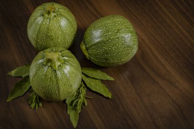 Ahşap masa üzerinde epazot yaprakları olan yuvarlak balkabaklarının bileşimi