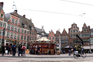 Gent, Belçika 'daki meydanda tarihi binalar ve Noel Pazarı' nın tadını çıkaran insanlar var.. 