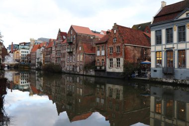 Sudaki ev ve veranda diğer binalar ve bunların yansımaları Ghent, Belçika 'daki kanalda.. 