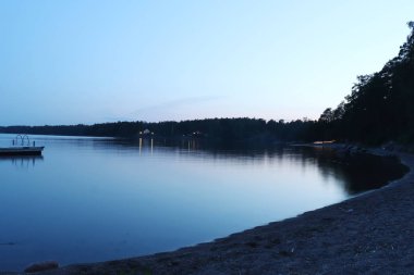 Finlandiya, Helsinki 'de gecenin bir yarısı bir gölün yanında kıyı şeridi. 