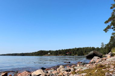 Finlandiya, Helsinki 'de bir gölün kıyısındaki kayalıklarda temmuz ayında sıcak bir yaz sabahı. 