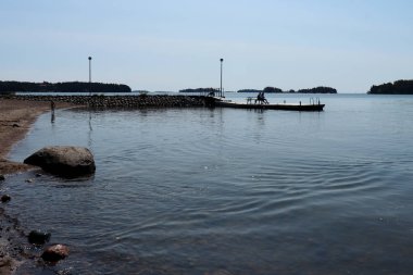 İnsanlar sabahın erken saatlerinde Finlandiya 'nın Helsinki kentindeki bir gölde kıyı şeridinden taşan su ile eğleniyorlar.. 
