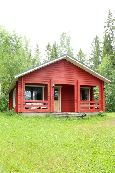 Small red cabin in the woods next to Lake Saimaa in northern Finland.