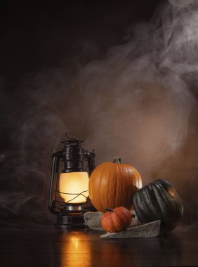 Balkabaklarının etrafında tüttür ve bir fenerle ahşap bir masada kabak ye.. 