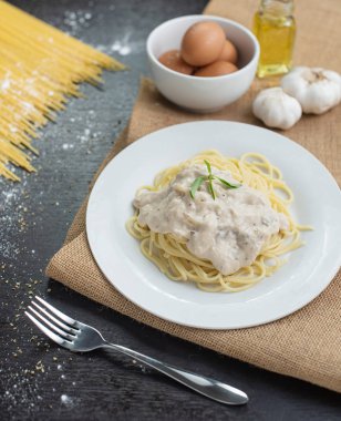 Ahşap masa arka plan üzerinde beyaz plaka spagetti cabonara.