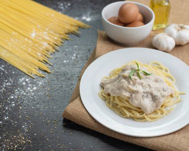 Ahşap masa arka plan üzerinde beyaz plaka spagetti cabonara.