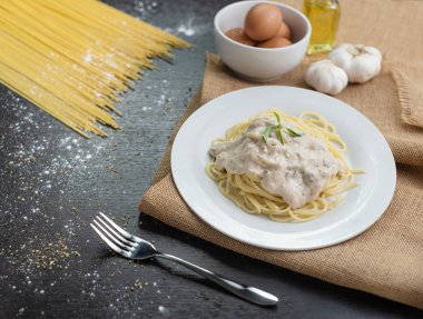 Ahşap masa arka plan üzerinde beyaz plaka spagetti cabonara.