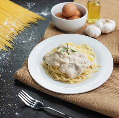 Ahşap masa arka plan üzerinde beyaz plaka spagetti cabonara.