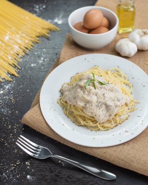 Ahşap masa arka plan üzerinde beyaz plaka spagetti cabonara.